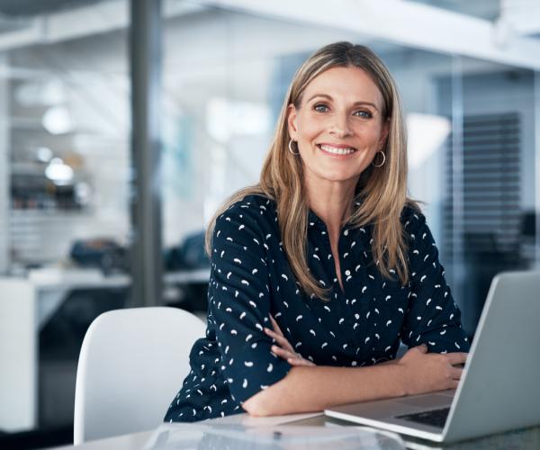 Portrait of a mature businesswoman using a laptop at her desk in a modern office