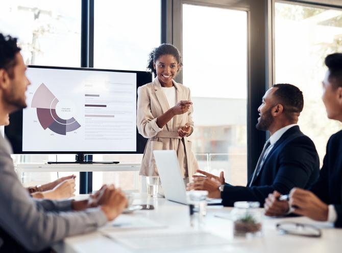 Businesswoman standing and presenting to a group of people 