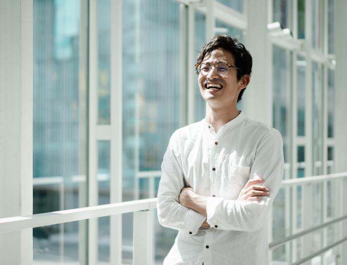 Young smiling businessman in a hallway with glass windows